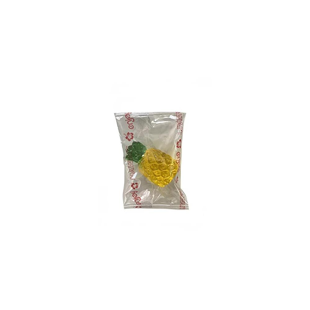 Close-up of single 3D pineapple gummy candy in transparent wrapper with green top and yellow body